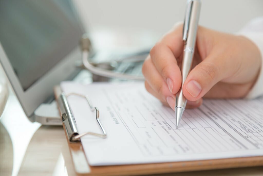 close-up-doctor-filling-out-prescription