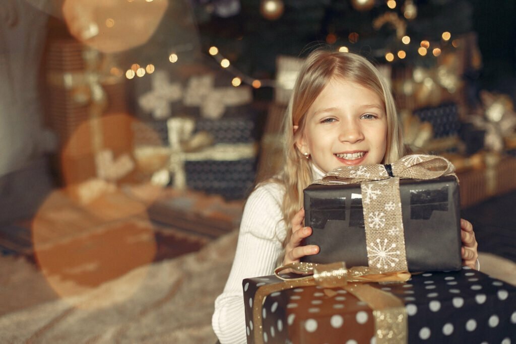 little-girl-white-sweater-near-christmas-tree-with-present
