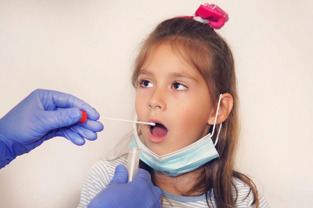 Doctor Doing Coronavirus Test For girl Patient. DNA test. Collection of mucus from the throat for research in the laboratory. Taking a saliva sample