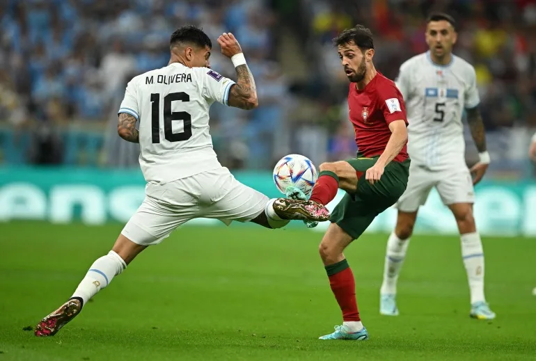Fotbal Fotbal - Cupa Mondială FIFA Qatar 2022 - Grupa H - Portugalia v Uruguay - Stadionul Lusail, Lusail, Qatar - 28 noiembrie 2022 Mathias Olivera din Uruguay în acțiune cu Bruno Fernandes din Portugalia REUTERS/Dylan Martinez