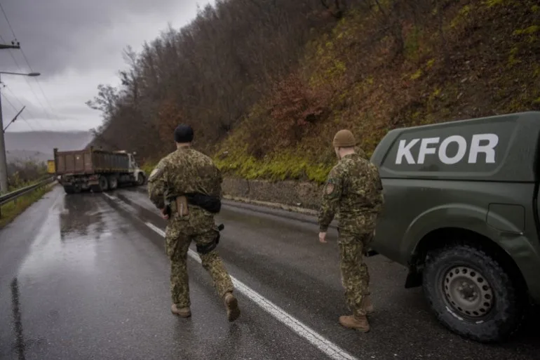 Soldații NATO care servesc în Misiunea de Menținere a Păcii din Kosovo (KFOR) inspectează o baricadă rutieră înființată de etnicii sârbi în apropierea orașului Zubin Potok