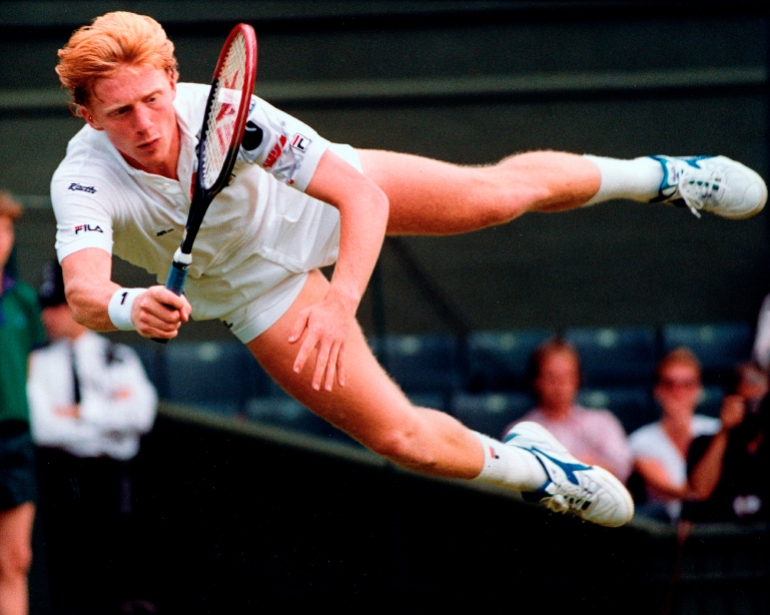 Boris Becker zboară prin aer pentru a întoarce o lovitură a australianului Wally Masur în timpul meciului din turul doi de la Wimbledon în 1990. [File photo: Dave Caulkin/AP]