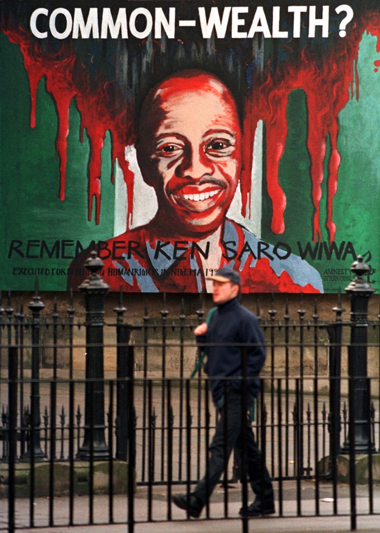 Un bărbat trece pe lângă portretul Amnesty International al autorului nigerian Ken Saro Wiwa