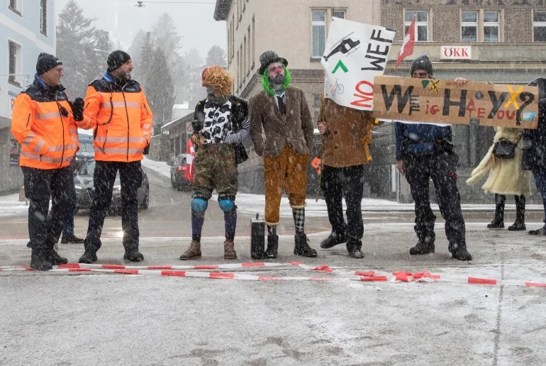 Activiștii pentru climă pozează lângă ofițerii de poliție elvețieni în timpul unui protest înaintea Forumului Economic Mondial (WEF) 2023 în stațiunea alpină Davos, Elveția, 15 ianuarie 2023. REUTERS/Arnd Wiegmann